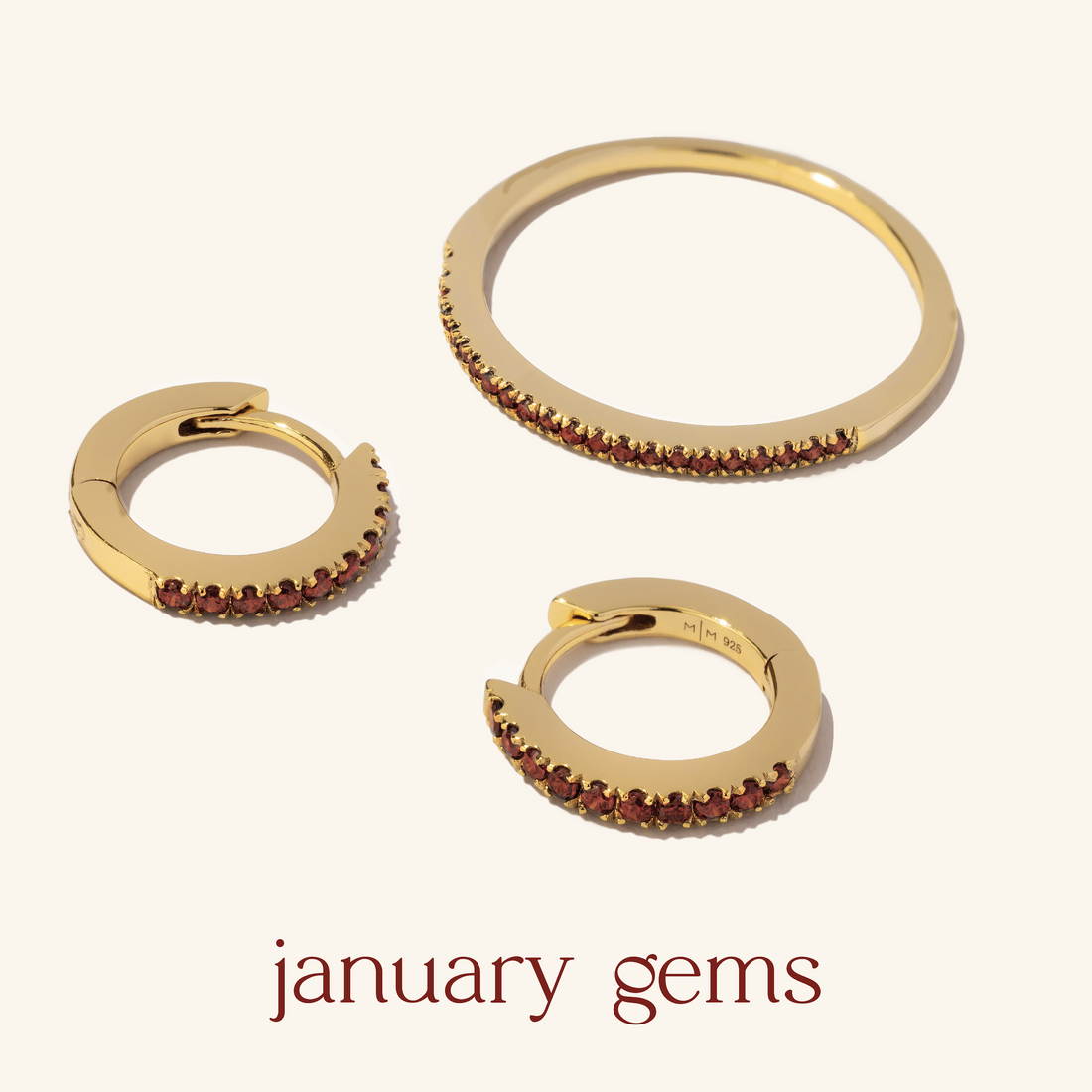 A ring and matching gold hoop earrings with red gemstones.