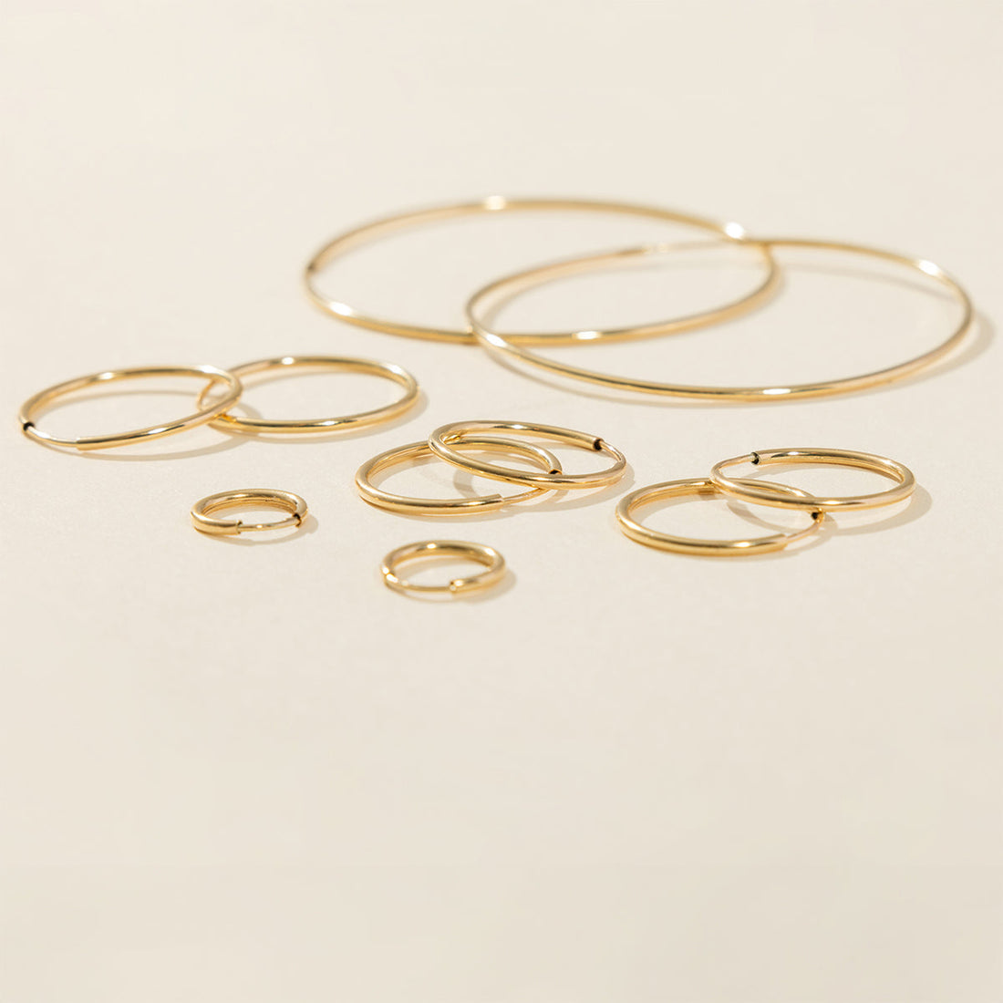 Flat lay of Live In hoop earrings in assorted styles.