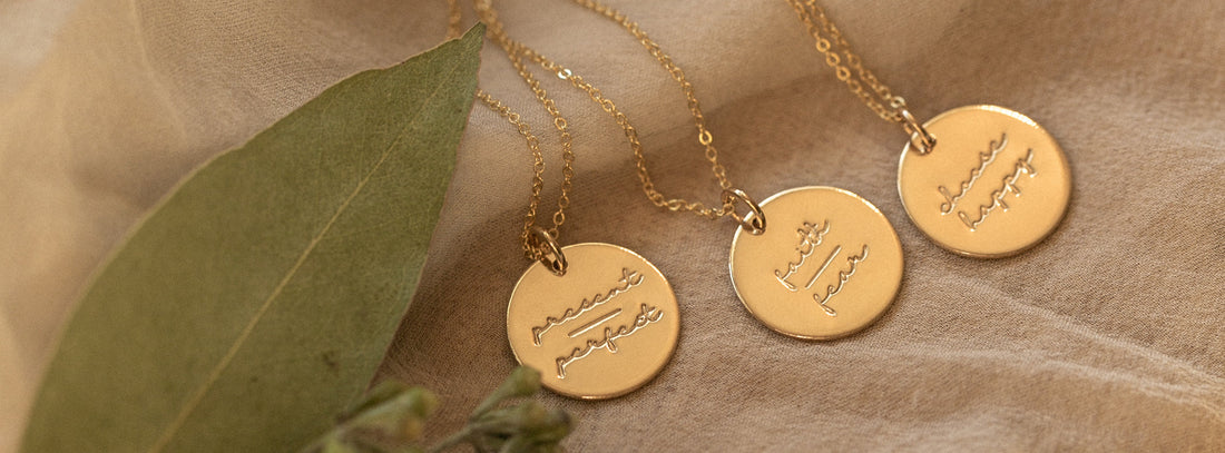 Three gold disc pendant necklace engraved with mantras.