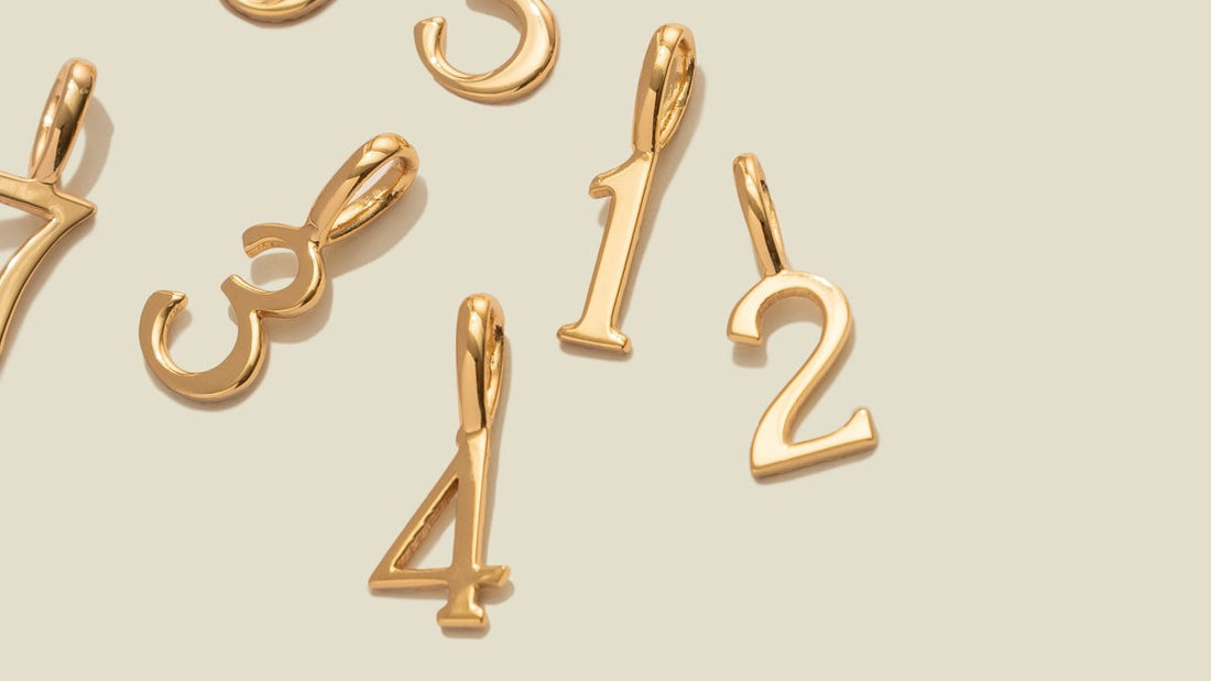 Gold number charms in a script font.