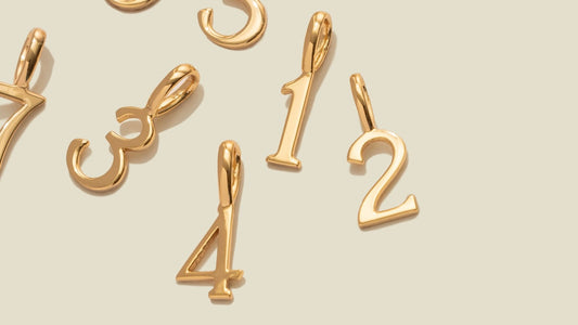 Gold number charms in a script font.