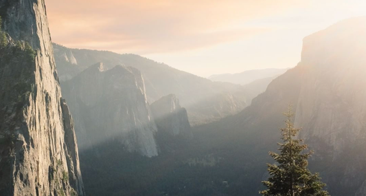 A mountain landscape with sunlight coming over the mountain.