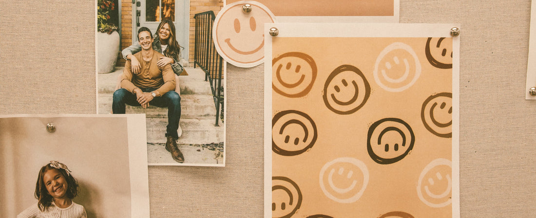 A pin board with smiley faces and family photos.