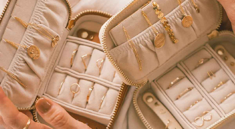 Two open jewelry cases holding multiple pieces of gold jewelry.