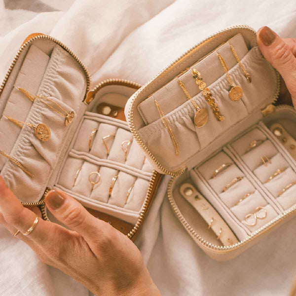 Two open jewelry cases holding multiple pieces of gold jewelry.