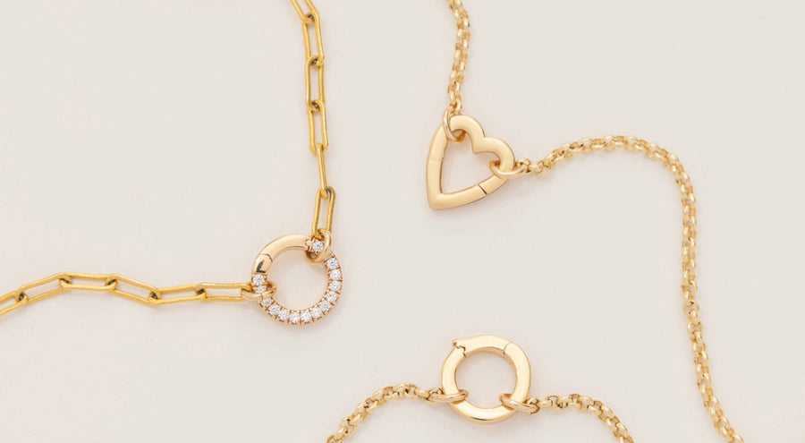 Three gold charm necklaces, each with a different style/shape of ring in the center to hold charms.