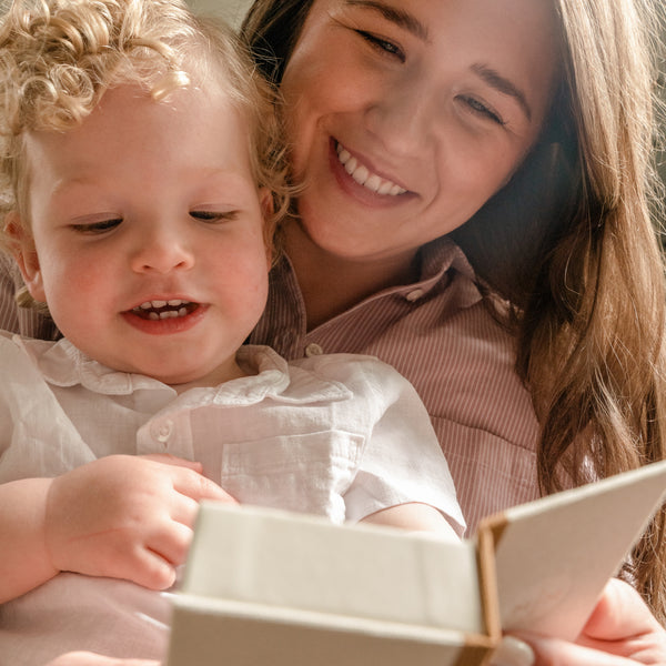 A woman holding her child and a small jewelry box.