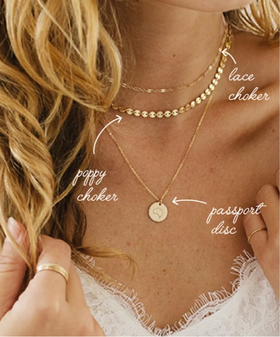 A woman wearing three different styles of gold necklaces in different lengths.