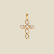 Gold cross pendant made of bezel-set pearl stones, suspended against a neutral background.