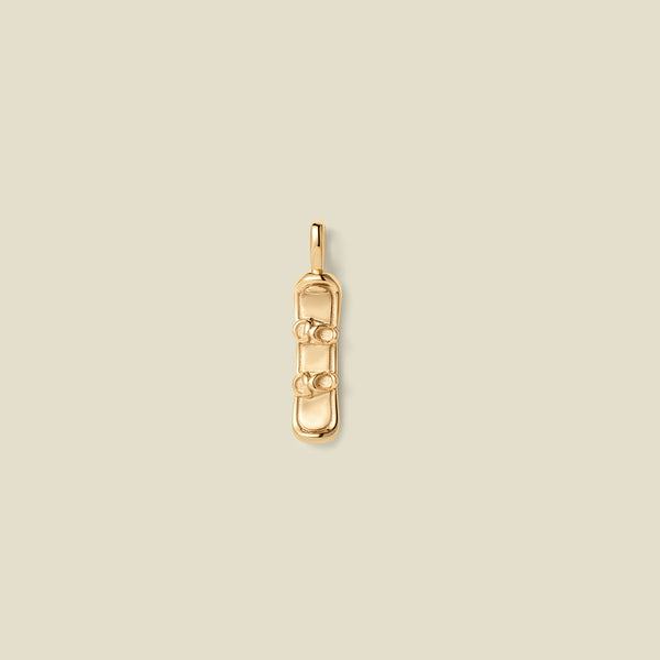 A gold pendant shaped like a snowboard with details, centered on a light beige background.
