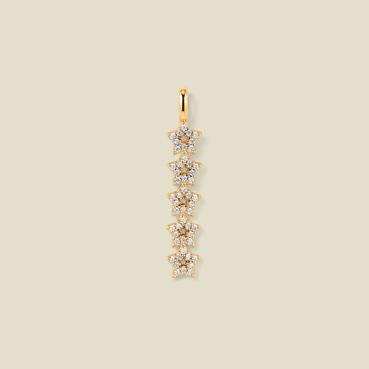 A gold pendant charm with five stars stacked vertically with clear stones, set against a solid beige background.