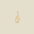 A polished gold initial pendant charm shaped like the letter 'G' in a cursive script, centered on a solid light beige background.