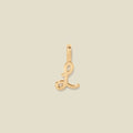 A polished gold initial pendant charm shaped like the letter 'L' in a cursive script, centered on a solid light beige background.