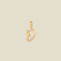 A polished gold initial pendant charm shaped like the letter 'O' in a cursive script, centered on a solid light beige background.