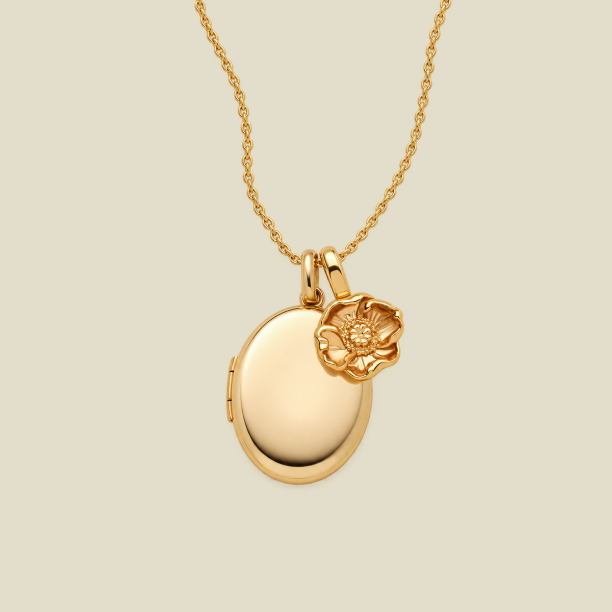 A gold locket necklace with a small poppy flower charm, displayed on a light beige background.