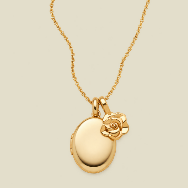 A polished gold locket necklace with an oval pendant and a small rose charm, shown on a light beige background.