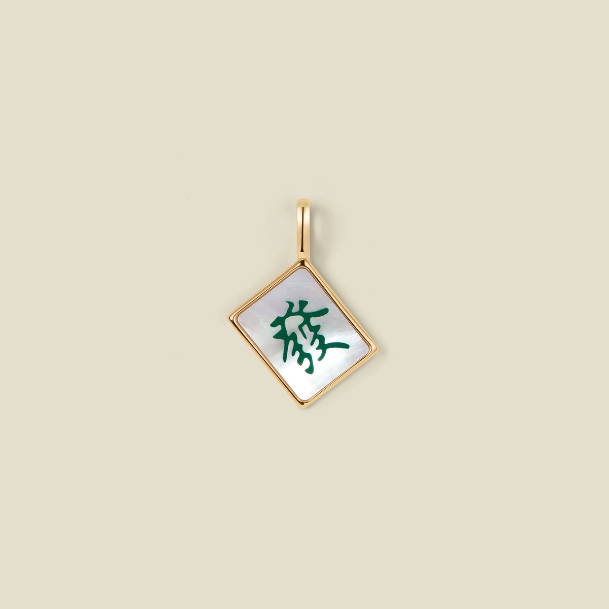 A square diamond-shaped mahjong tile pendant with a gold-tone border and a white inlay featuring a green Chinese character, shown on a solid beige background.