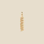 A vertical gold-tone pendant spelling 'MAMA' in an openwork font, centered on a solid light beige background.