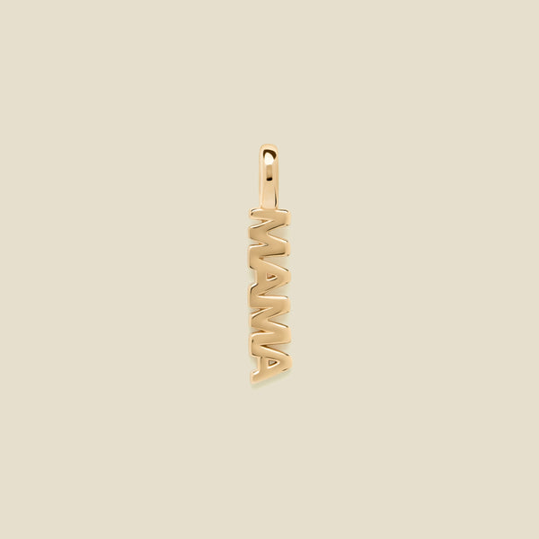 A vertical gold-tone pendant spelling 'MAMA' in an openwork font, centered on a solid light beige background.