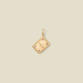 A gold book pendant charm with the word 'SMUT' engraved in the center and four pink accent stones on the corners.