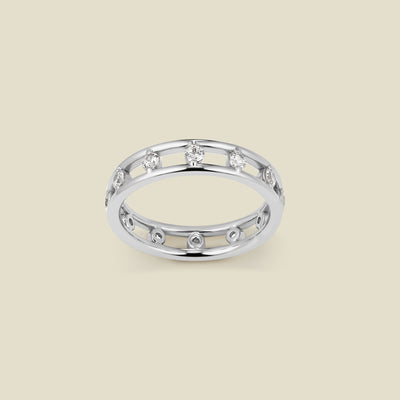 A silver eternity statement ring consisting of two thin ring bands connected by marquise-cut clear stones, shown against a solid beige background.