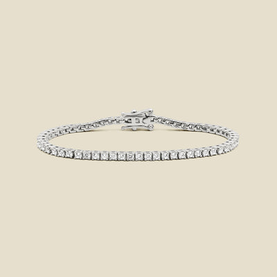 A silver tennis bracelet with clear square-cut gemstones, displayed on a solid light beige background.