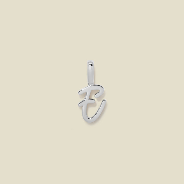 A polished silver initial pendant charm shaped like the letter 'E' in a cursive script, centered on a solid light beige background.