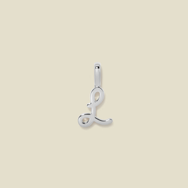 A polished silver initial pendant charm shaped like the letter 'L' in a cursive script, centered on a solid light beige background.