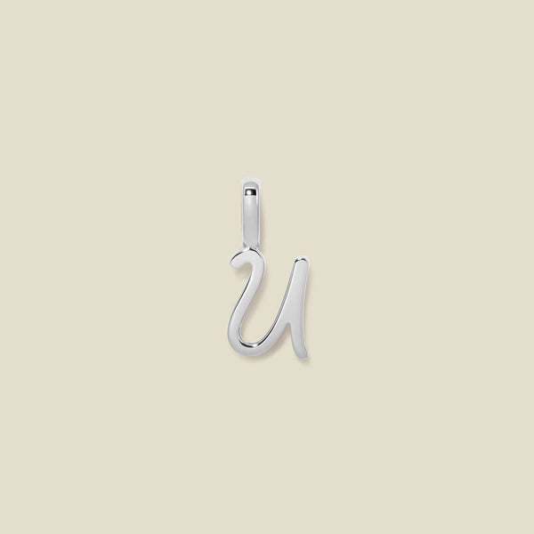 A polished silver initial pendant charm shaped like the letter 'U' in a cursive script, centered on a solid light beige background.