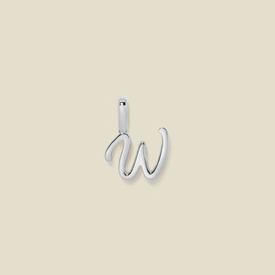 A polished silver initial pendant charm shaped like the letter 'W' in a cursive script, centered on a solid light beige background.