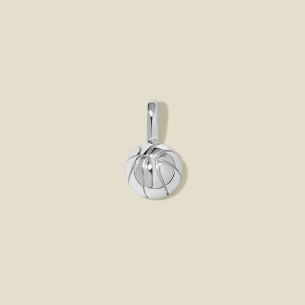 A silver basketball charm with seam details, set against a solid beige background.