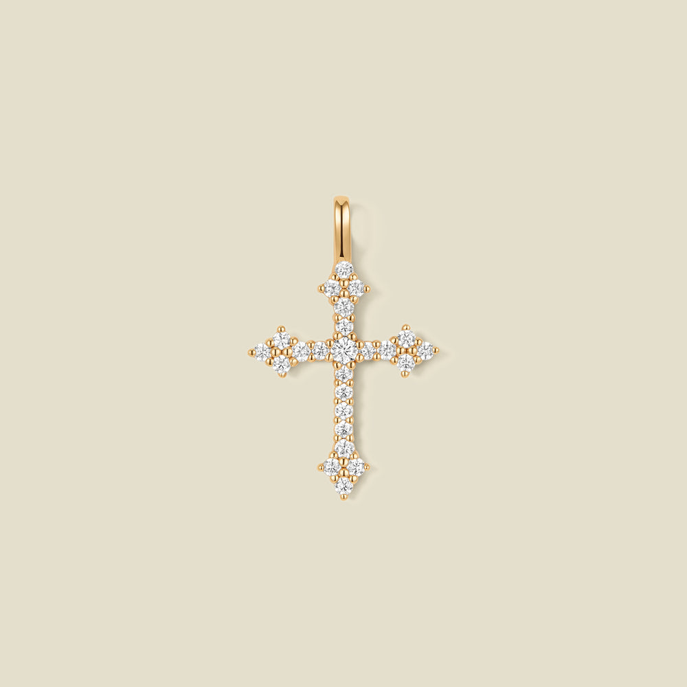 A gold cross pendant charm with clear stones across the front.