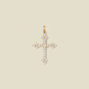 A gold cross pendant charm with clear stones across the front.