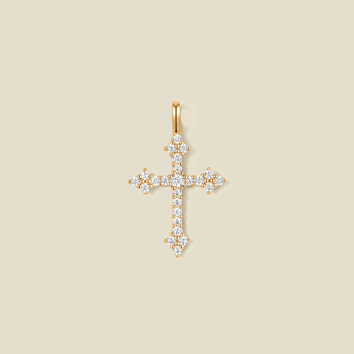 A gold cross pendant charm with clear stones across the front.