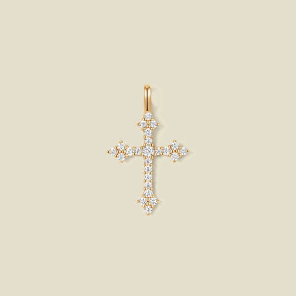 A gold cross pendant charm with clear stones across the front.