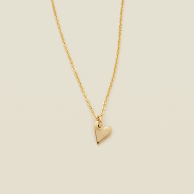 A gif showing a delicate gold pendant chain necklace starting with a blank gold mini heart charm, then adding a letter engraving and multiple other engraved heart charms to the chain.