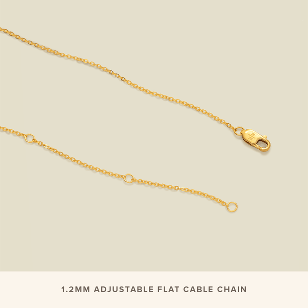 The end of a dainty gold chain necklace, showing the gold lobster clasp with the logo 'M|M' and three jump rings on the other side. There is a white text box across the bottom that says '1.2mm Adjustable Flat Cable Chain'.
