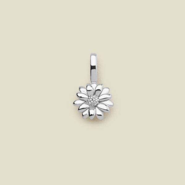 A small silver daisy flower charm, shown centered on a solid light beige background.