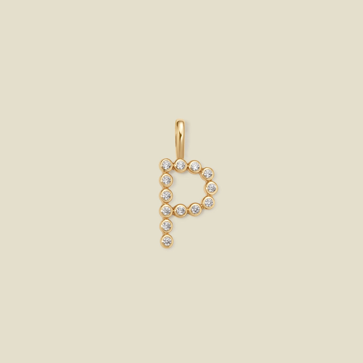 A gold letter 'P' pendant charm embellished with small clear round gemstones, centered on a solid light beige background.