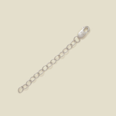 A silver lobster clasp connected to a short chain of oval links, photographed on a plain warm beige background.