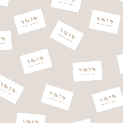 Multiple white rectangular cards with brown floral outlines and the words 'MADE BY MARY' on a light beige surface.