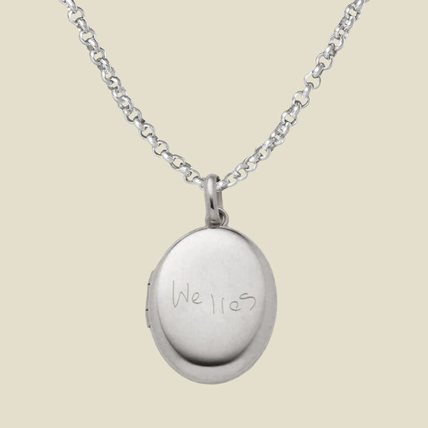 Silver locket necklace with 'Welles' engraving on a beige background