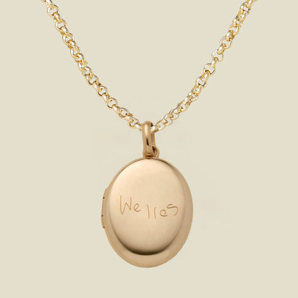 A gold locket necklace with an oval pendant engraved with the name 'Welles', shown on a light beige background.