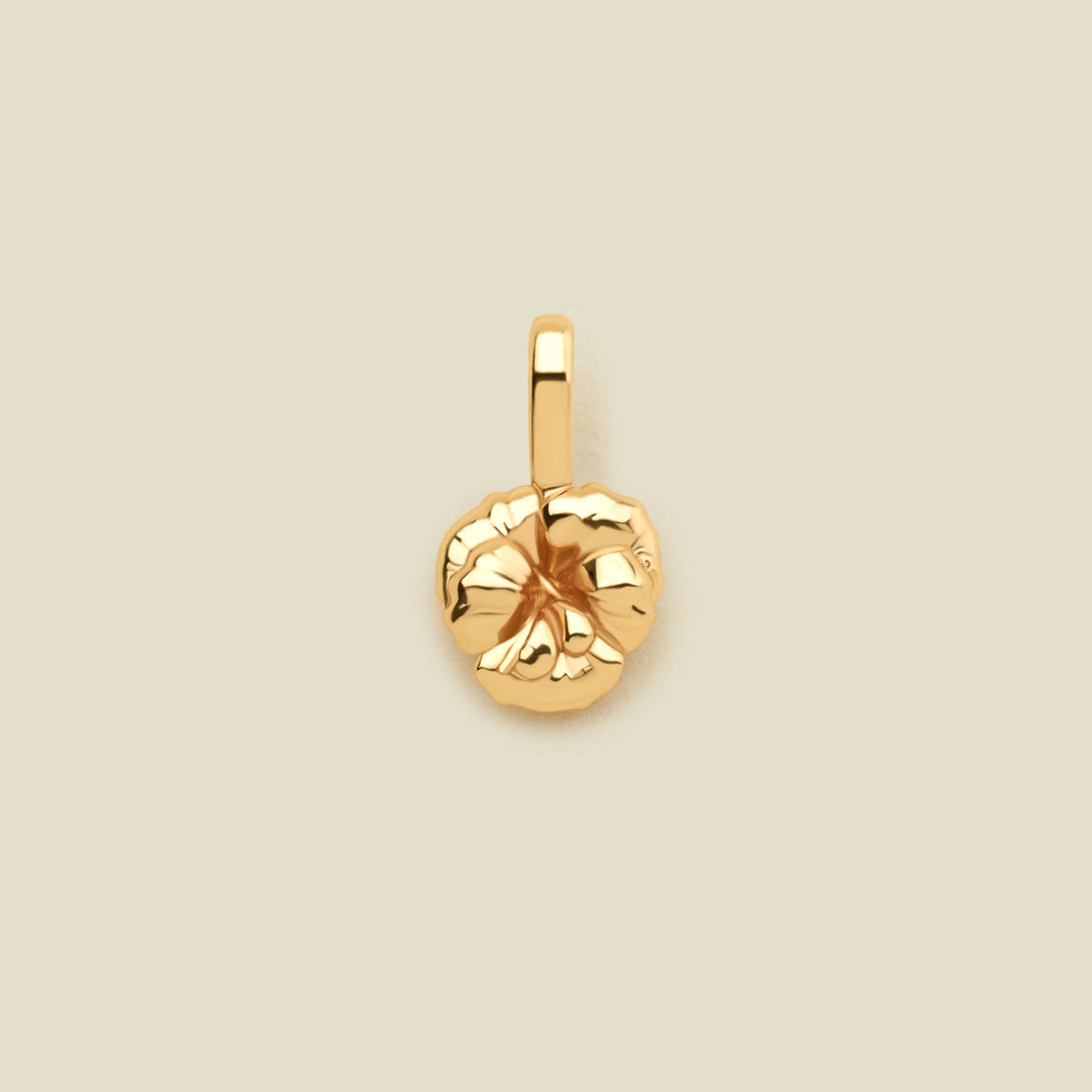 A small gold violet flower charm, shown on a solid light beige background.