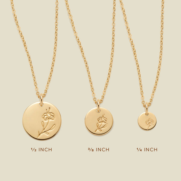 Three gold pendant necklaces, each with a different size of round flat disc and engraved with varying violet flower designs. Below the necklaces there is the text '1/2 INCH', '3/8 INCH', and '1/4 INCH'.