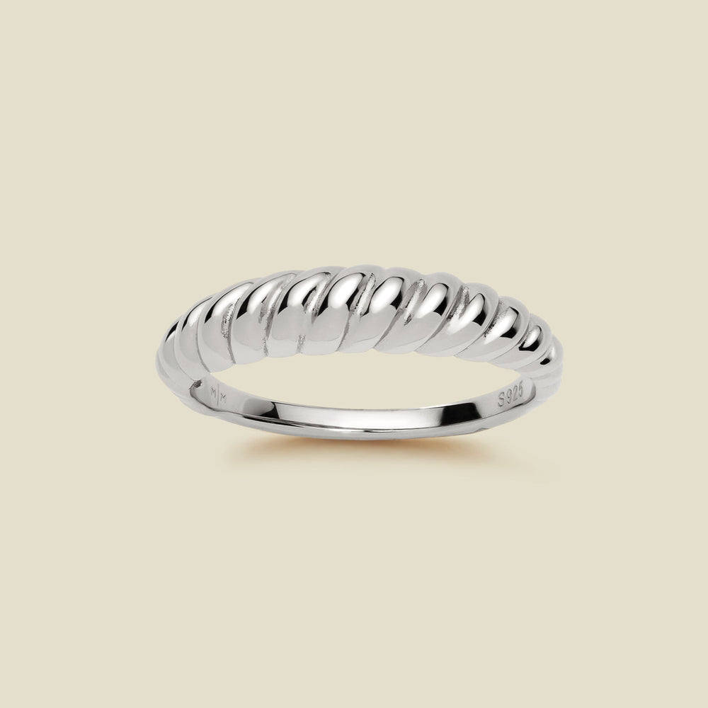A thick silver twisted rope ring with a polished finish, displayed on a solid light beige background.