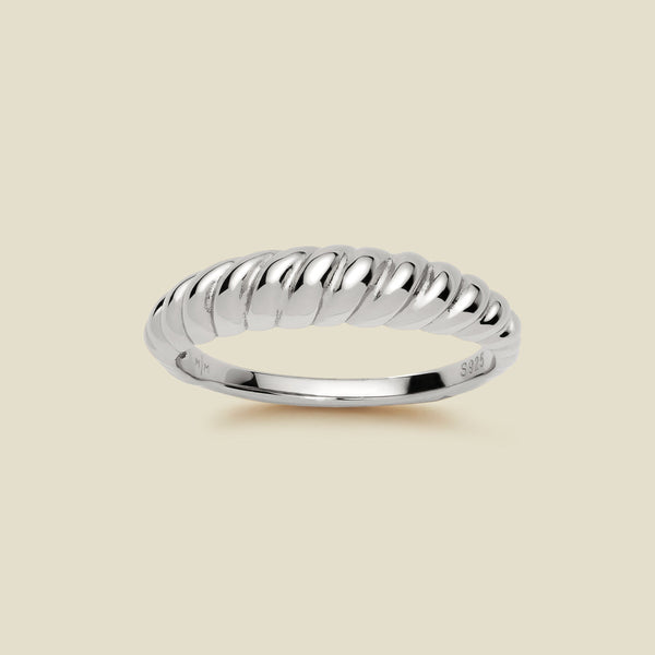 A thick silver twisted rope ring with a polished finish, displayed on a solid light beige background.