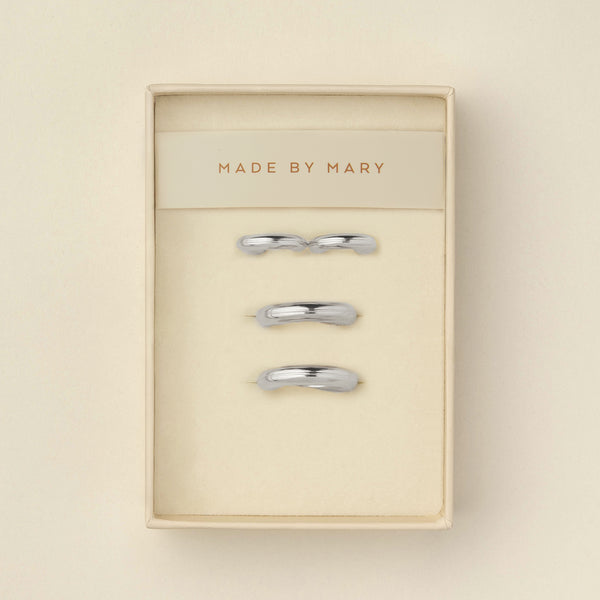 Two pairs of polished wide silver hoops, one smaller and one larger, displayed in a cream-colored presentation box with the brand name 'MADE BY MARY' printed on the insert.