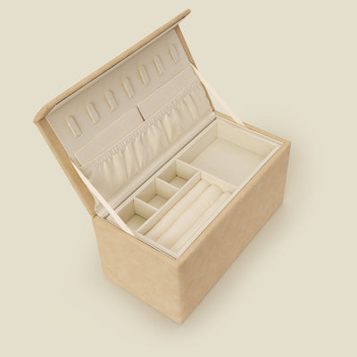 A cream colored leather rectangular jewelry box shown open, showcasing multiple felt necklace hooks, a large pocket, and multiple ring slots and small square containers for holding jewelry.