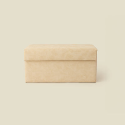 A rectangular cream leather storage box with a hinged lid, shown against a solid light beige background.